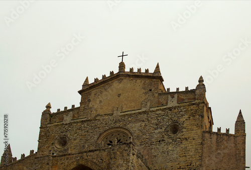 Picturesque landscape view of ancient stone Erice Cathedral in small mountain village Erice. Notable landmark of Sicily. Travel and tourism concept. Cloudy sky background