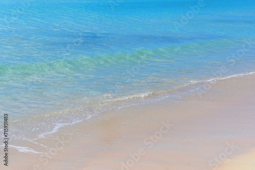 Blue ocean waves on sandy beach. 