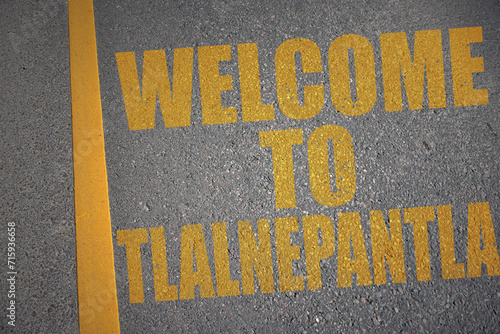 asphalt road with text welcome to Tlalnepantla near yellow line. photo