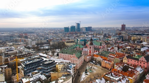 Aerial view of Poznan s historic market square in winter  showcasing the charming old townhouses adjacent to the square. The drone captures the city s architectural heritage under a winter sky.