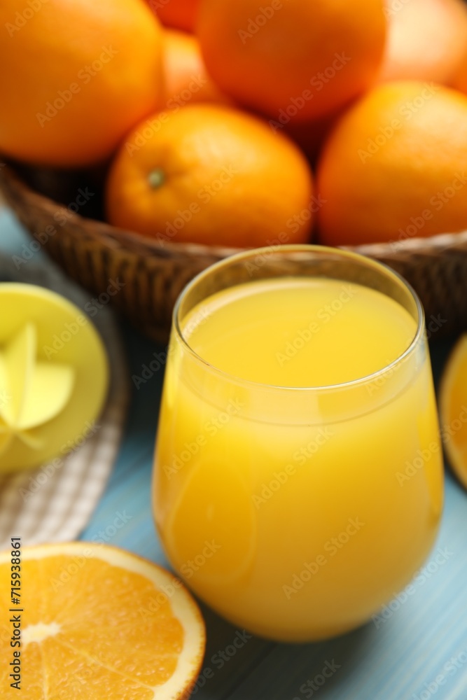 Freshly made juice, oranges and reamer on blue table Freshly made juice, oranges and reamer on blue table