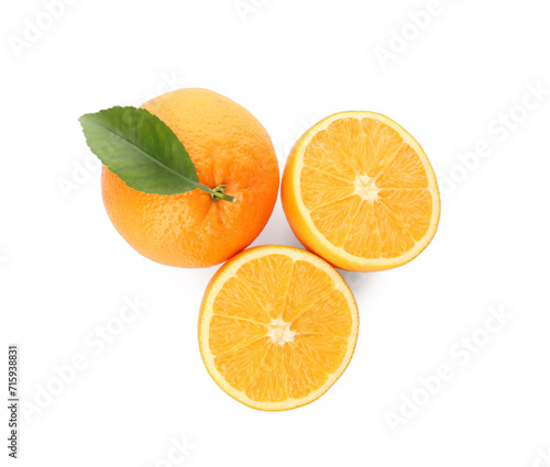 Cut and whole fresh ripe oranges with green leaf on white background, top view