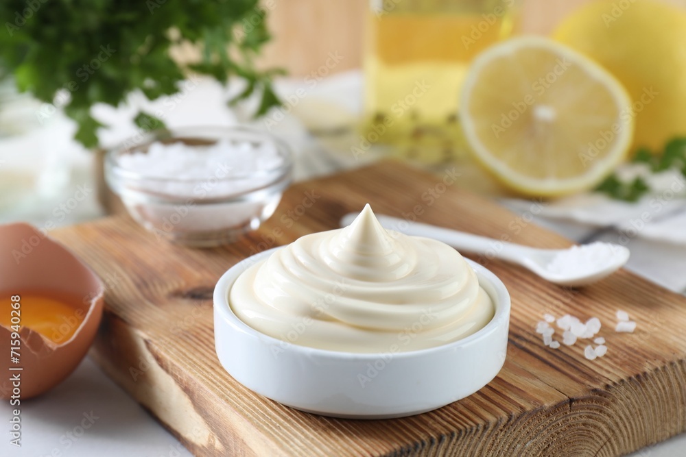 Fresh mayonnaise sauce in bowl and ingredients on table Fresh mayonnaise sauce in bowl and ingredients on table