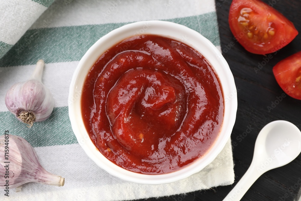 Organic ketchup in bowl, fresh tomatoes and garlic on table, flat lay. Tomato sauce Organic ketchup in bowl, fresh tomatoes and garlic on table, flat lay. Tomato sauce