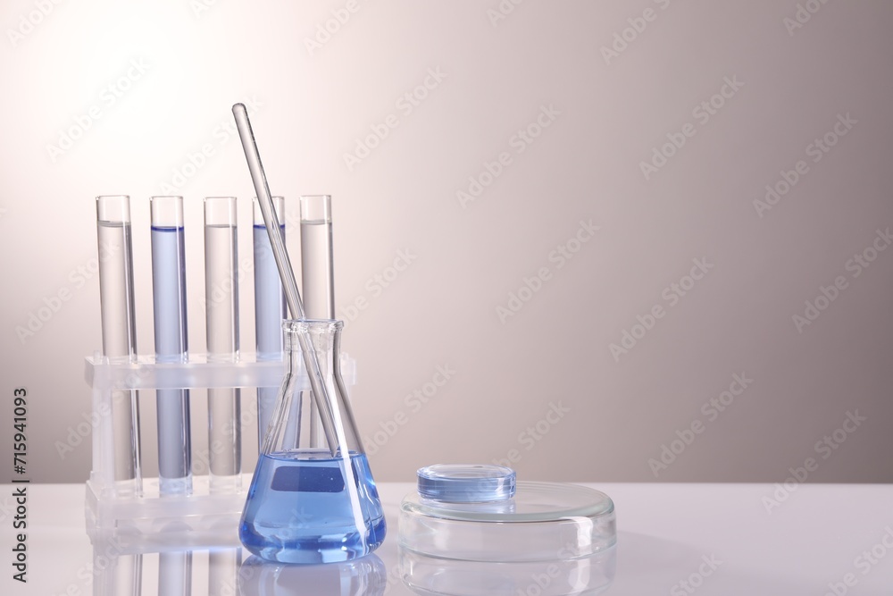 Laboratory analysis. Different glassware on table against light background, space for text Laboratory analysis. Different glassware on table against light background, space for text