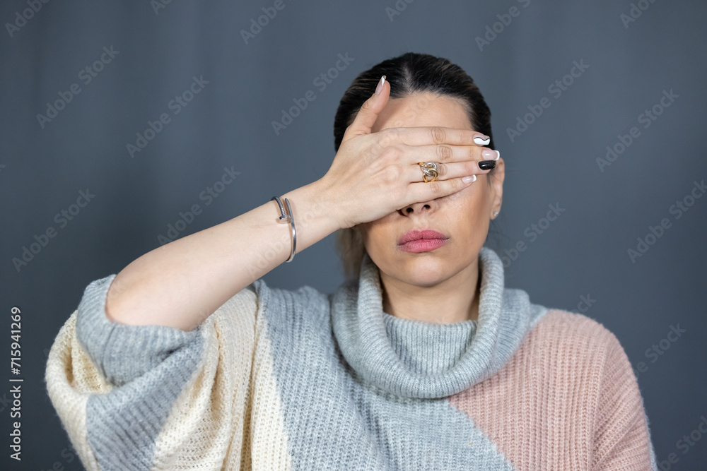 Portrait of an oriental woman covering her eyes with her hands Portrait of an oriental woman covering her eyes with her hands
