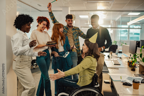 Diverse people celebrating their colleague with disability birthday in office
