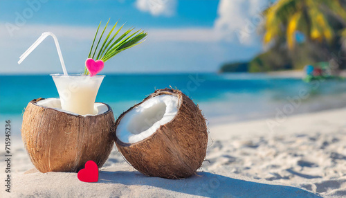 Valentine's day in the tropics. Two coconut on the sand with red hearts on blurred ocean background