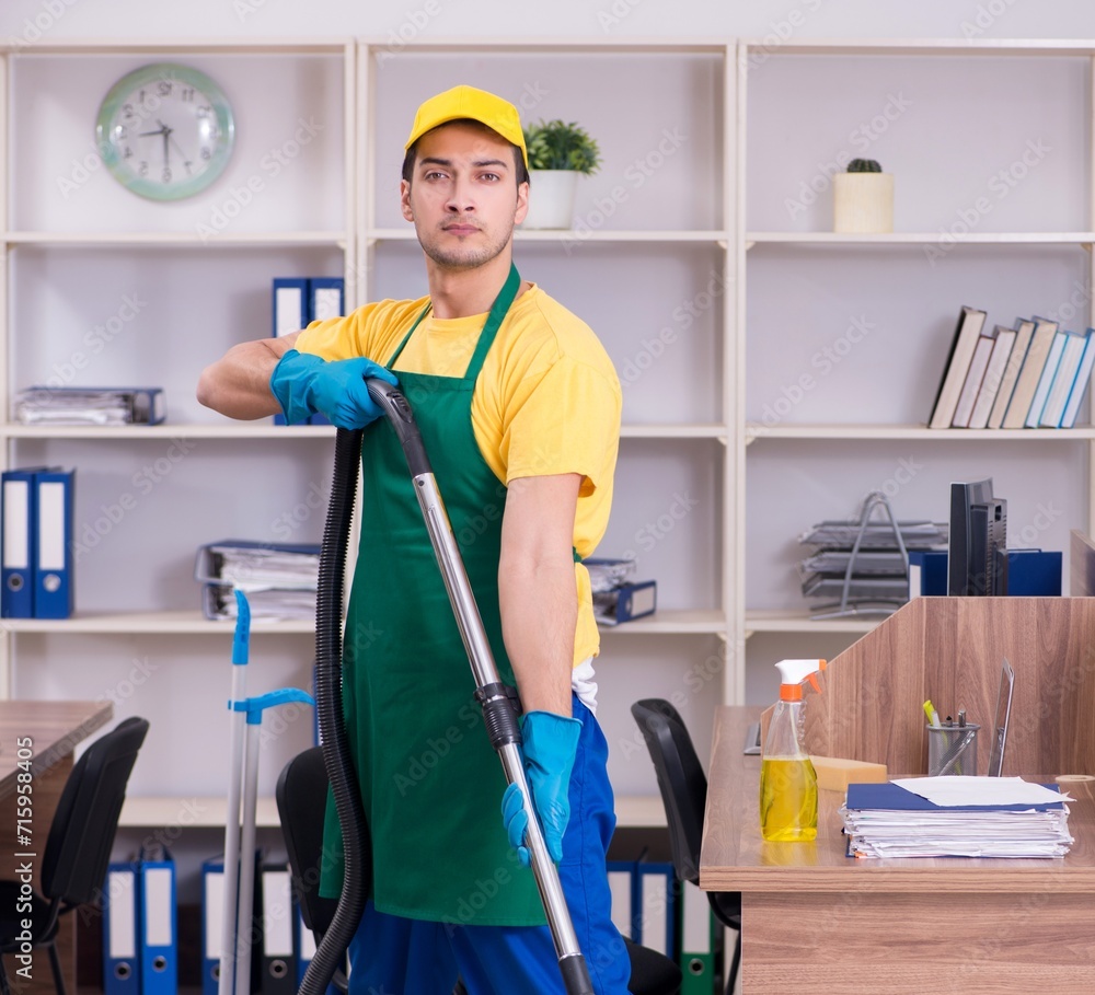 Young male contractor cleaning the office Young male contractor cleaning the office