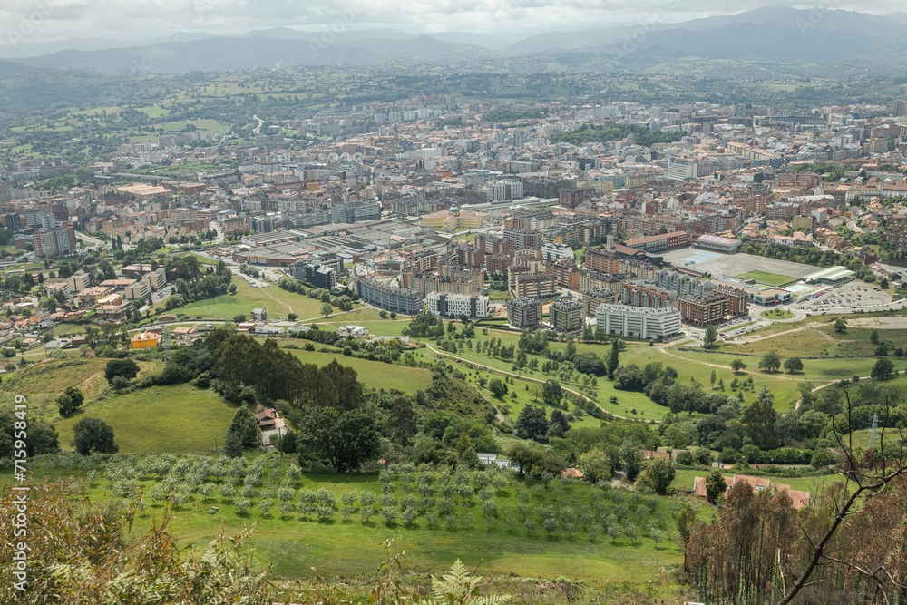 A vast landscape of the city of Oviedo in Spain. This small European city has a lot of mountains and trees surrounding the busy historic center. A vast landscape of the city of Oviedo in Spain. This small European city has a lot of mountains and trees surrounding the busy historic center.
