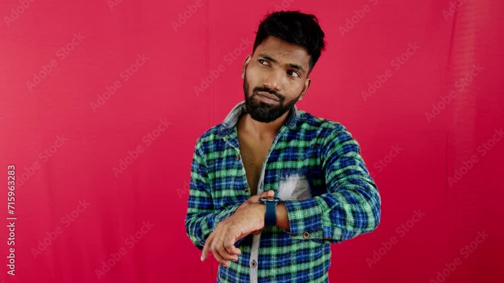 Thoughtful man in plaid shirt on red background looking away with hand on head expressing contemplation Thoughtful man in plaid shirt on red background looking away with hand on head expressing contemplation