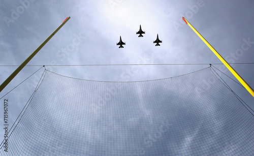 F-16 military jets fly over a football stadium between the goalposts as sky is seen above them during pre-game activities following the national anthem. 
