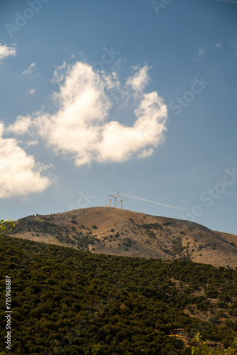 wind plant turbine green energy on Greece mountains against blue cloudy sky