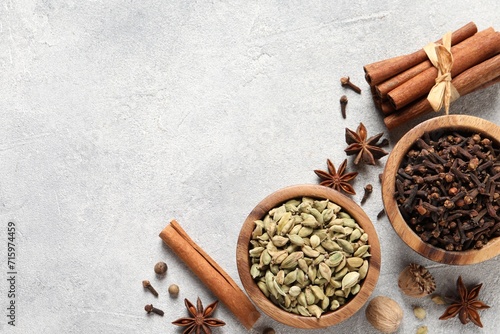 Different aromatic spices on light textured table, flat lay. Space for text