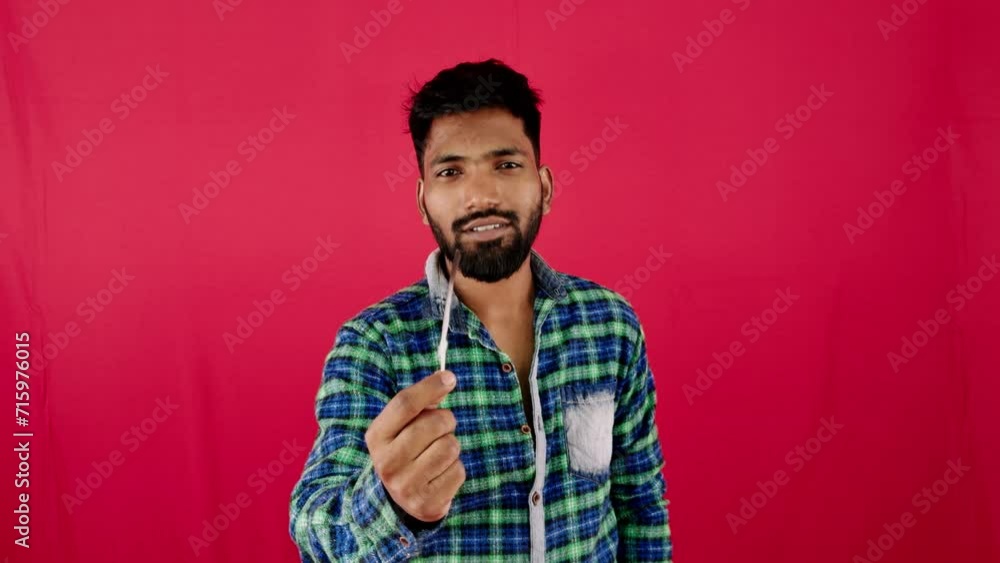Smiling man in plaid shirt posing against a vibrant red background side view with copy space Smiling man in plaid shirt posing against a vibrant red background side view with copy space