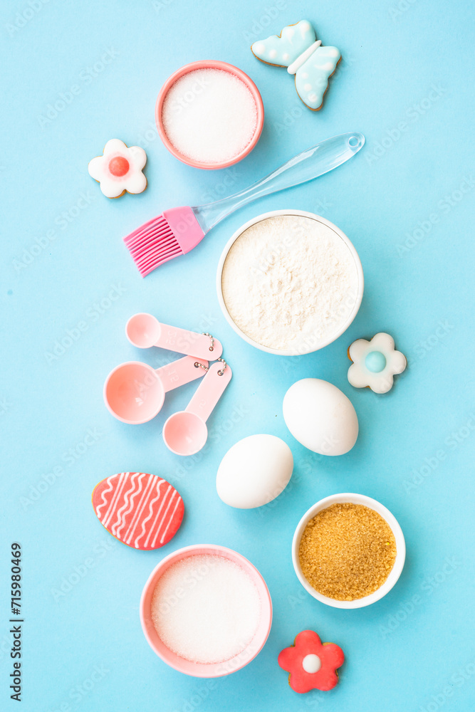 Easter baking background on blue. Flour, edds, sugar and gingerbread cookies. Top view with copy space. Easter baking background on blue. Flour, edds, sugar and gingerbread cookies. Top view with copy space.