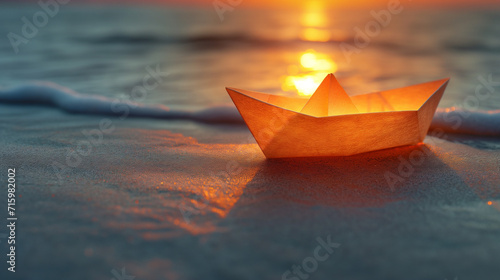 paper boat in shallow water of sea at sunset, space for text. paper boat on sandy beach near sea. Freedom, dreams and fantasies concept. photo