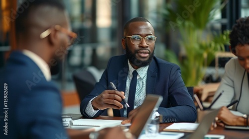 Three confident people in formalwear using technologies while discussing business in office together photo