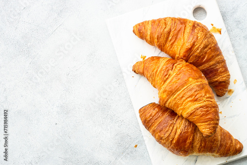 Fresh Croissants on white table. French bakery. Top view with space for text.