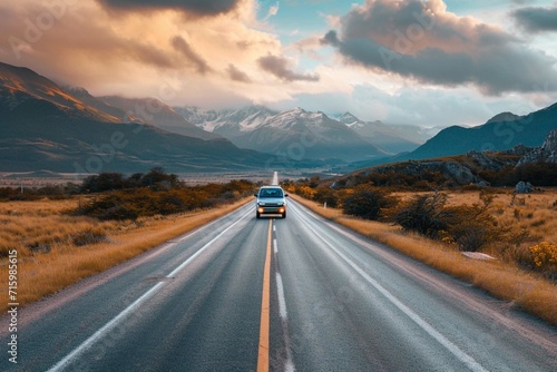Lonely automobile going along asphalt roadway on background of amazing highlands photo
