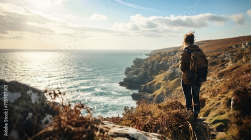 Person stood on a cliff overlooking the sea