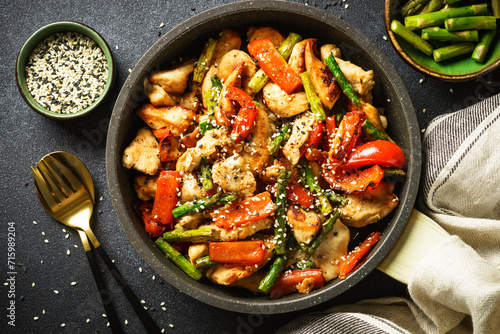 Chicken stir fry with vegetables at stone background. Flat lay image.