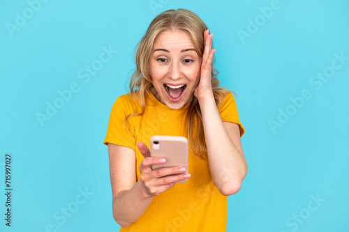 Shocked young woman looking at modern cellphone display