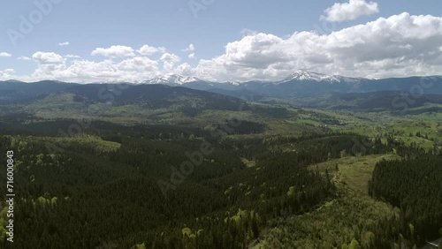 Aerial footage of  carpathian forests on a Yablunivskiy pereval with a view on Hoverla and Pip Ivan mountains on a horizon, Ukraine. photo