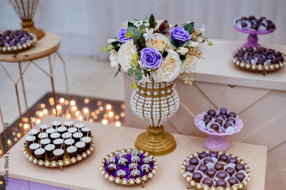 a table decorated with wedding sweets LED lights in the background