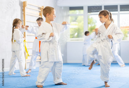 Karate kids in kimono sparring together during their group karate training