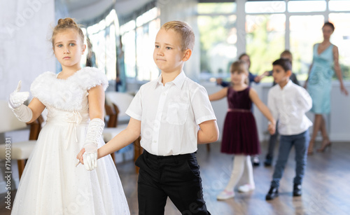 Active preteen children practicing ballroom dances in pairs during dancing classes © JackF
