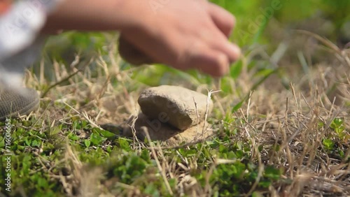 Child putting pebble pieces on one another