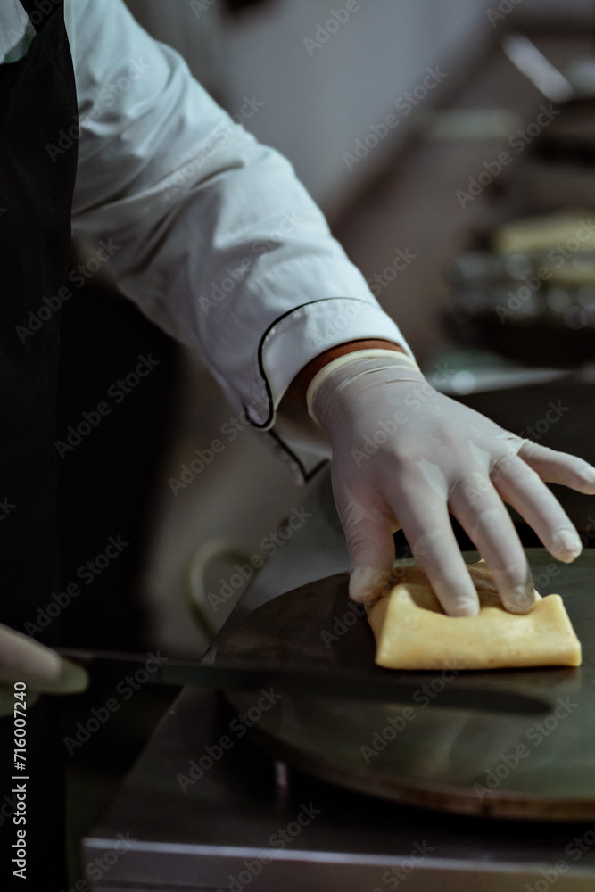 a waiter preparing crepes at a buffet table