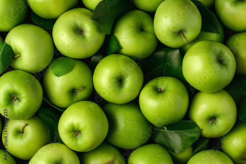 lots of green apples with leaves lying on top of each other, for background, top view