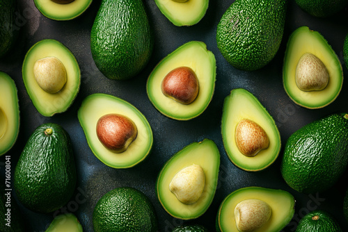 avocados cut in half lying on a green background