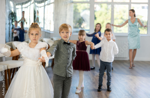 Group of preteen children movements of waltz in dance studio with female tutor