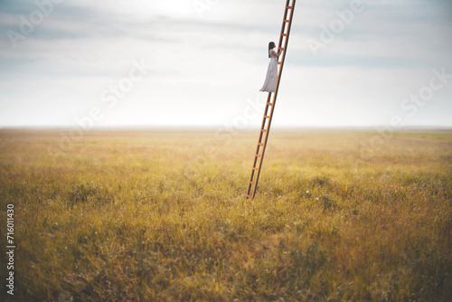 woman climbing a surreal ladder in the middle of a field reaching the sky, abstract concept