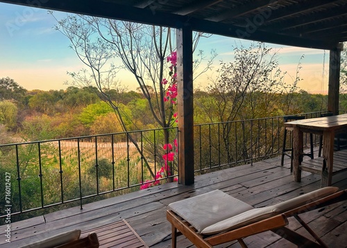 View of a desert landscape from a second story deck lined with red bougainvillea