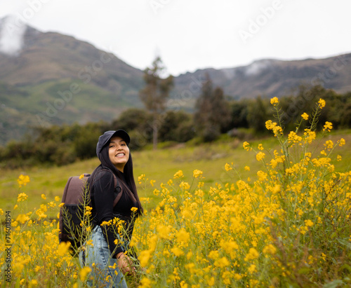 Exploradora de la naturaleza urbana Una chica atractiva con mochila entre flores amarillas. Estilo de vida, turista viajera