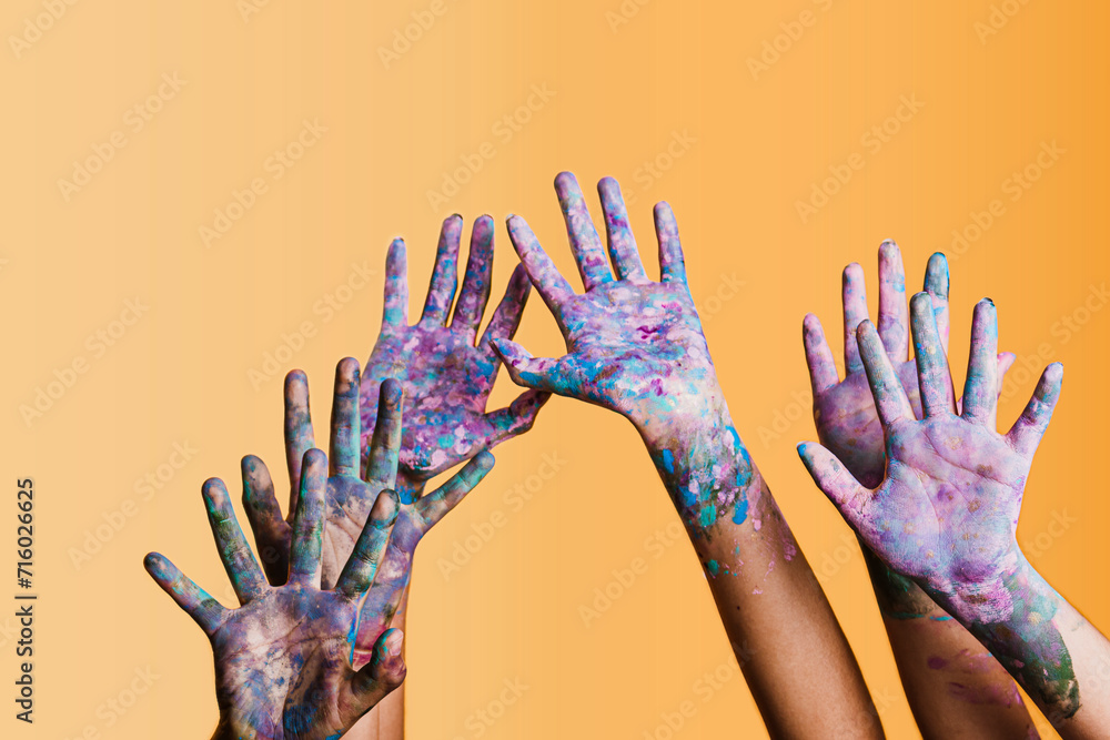 children raising paint-stained hands, group of children having fun with paint