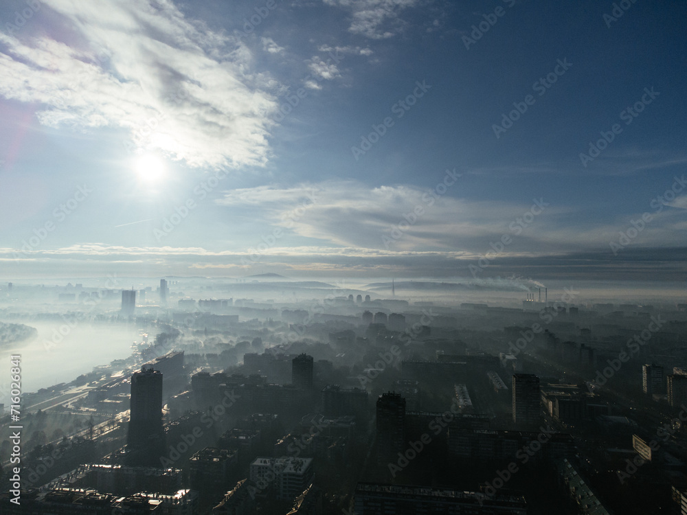 Drone aerial view of Belgrade city in the smog and fog in the morning. Zemun and New Belgrade district, Serbia, Europe.
