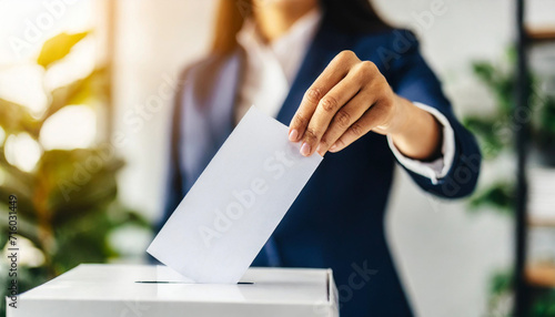 Woman's hand casts ballot into voting box, symbolizing freedom and democratic participation, with copy space