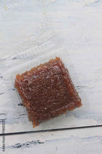 Indonesian food called wajik made of sticky rice and brown sugar in mica plastic on the table photo