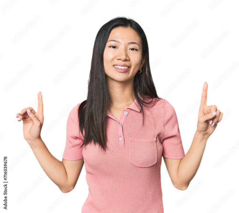 Young Chinese woman in studio setting indicates with both fore fingers up showing a blank space. Young Chinese woman in studio setting indicates with both fore fingers up showing a blank space.