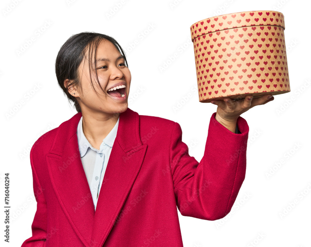 Young Chinese woman holding a heart-filled box raising fist after a victory, winner concept. Young Chinese woman holding a heart-filled box raising fist after a victory, winner concept.