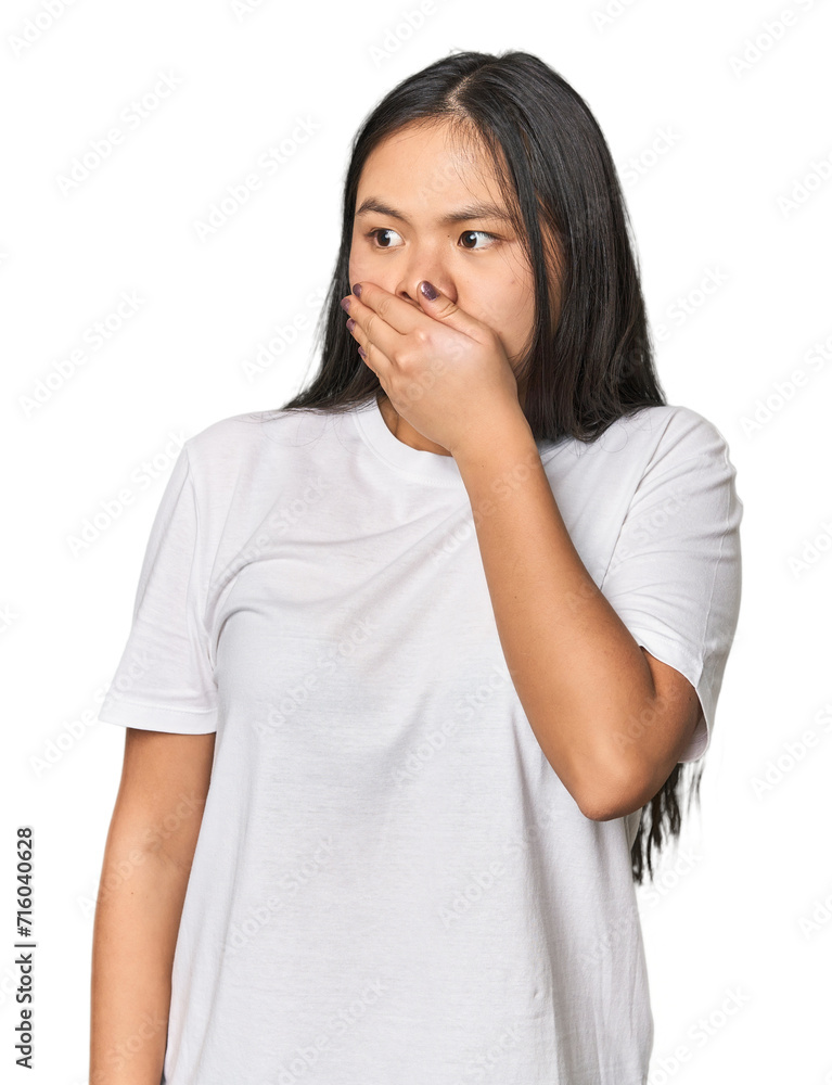 Young chinese woman isolated thoughtful looking to a copy space covering mouth with hand. Young chinese woman isolated thoughtful looking to a copy space covering mouth with hand.