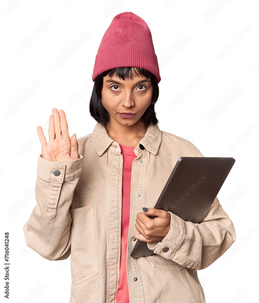 Young Hispanic student with laptop in studio smiling and raising thumb up Young Hispanic student with laptop in studio smiling and raising thumb up