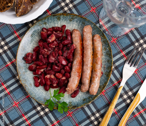 Traditional Catalan dish of fried pork sausage Butifarra with a side dish of beans