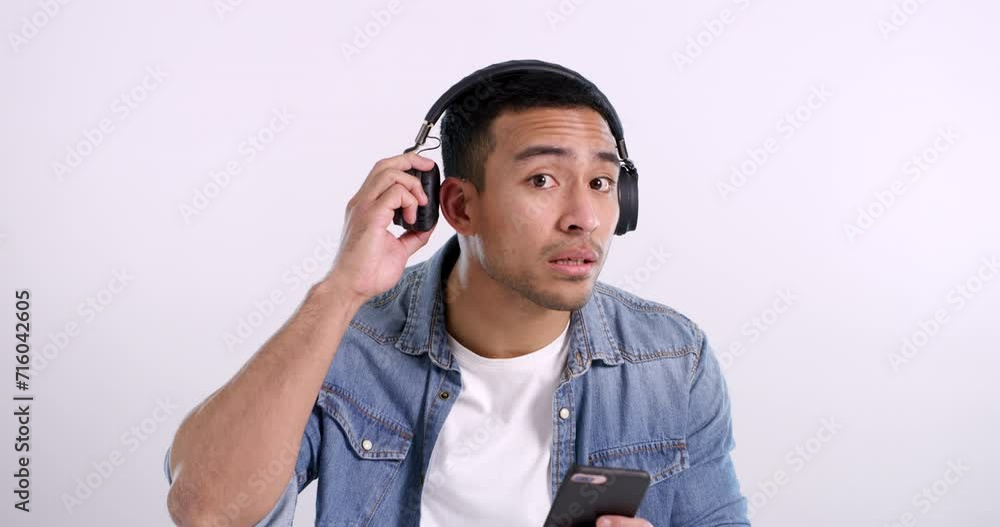 Face, man and remove headphones with smartphone, streaming music and guy on a white studio background. Portrait, model and mockup space with headset, cellphone and hearing with radio, sound or listen Face, man and remove headphones with smartphone, streaming music and guy on a white studio background. Portrait, model and mockup space with headset, cellphone and hearing with radio, sound or listen