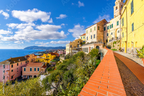 A terrace overlooks the blue Mediterranean Sea and town at the hilltop medieval town of Cervo, Italy, in the Imperia Province along the Ligurian Coast. photo